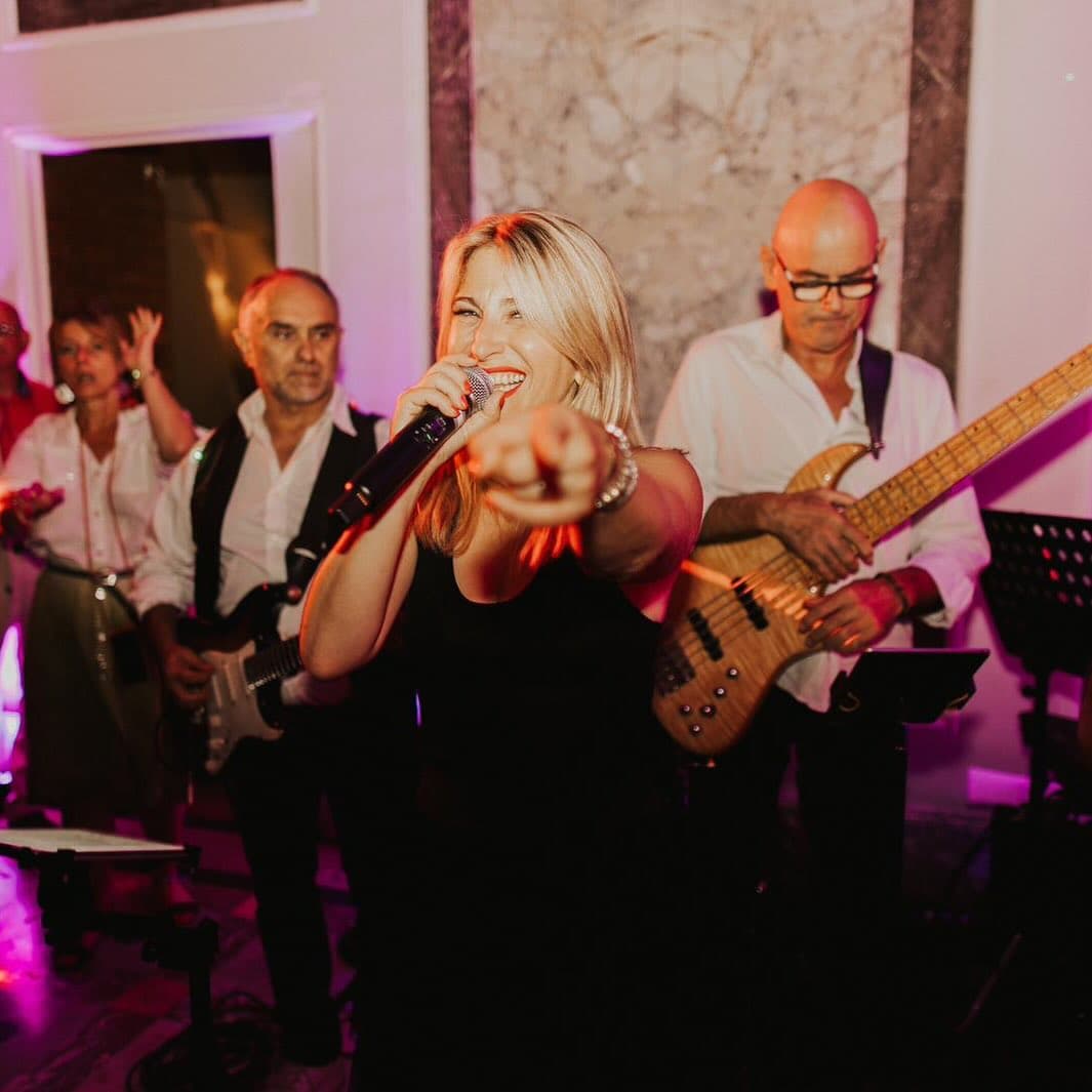Le groupe ROCK'ELLE pose fièrement devant un rivage lumineux, incarnant l'esprit musical de La Rochelle et de l'Île de Ré.